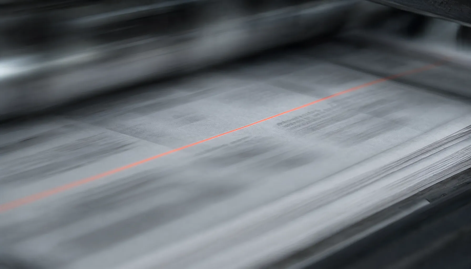 Newspaper pages running through a printing press